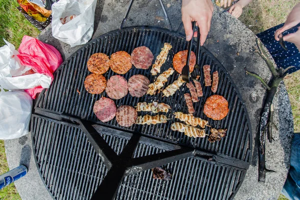 Deliciosa hamburguesa a la parrilla y carne de pollo en la barbacoa en el picnic — Foto de Stock