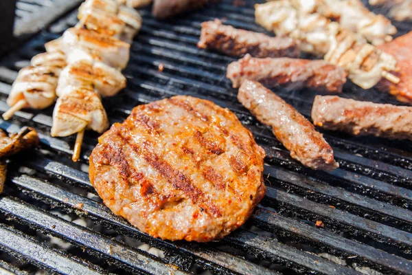 Grilled burger and chicken meat on barbecue at picnic — Stock Photo, Image