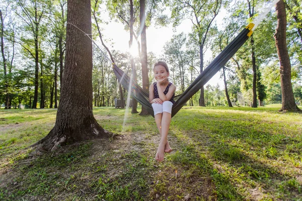 Szczęśliwy portret małej dziewczynki relaks na hamaku w lesie — Zdjęcie stockowe