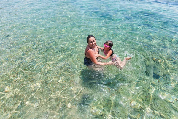 Мать и дочь веселятся вместе в море во время отпуска — стоковое фото