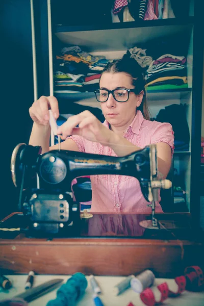 woman seamstress using retro sewing machine