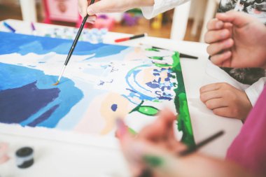 tuval üzerinde fırça boyama ile küçük sanatçı eller