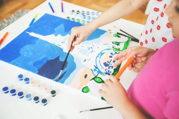 Tuval üzerinde fırça boyama ile küçük sanatçı eller — Stok fotoğraf