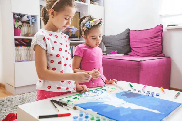 Twee kleine meisjes schilderen op doek — Stockfoto