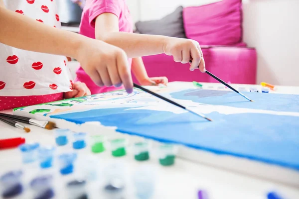 Piccole mani d'artista con pennello su tela — Foto Stock