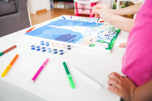 Little artist hands with brush painting on canvas — Stock Photo, Image