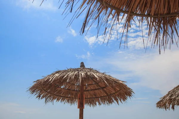 Pare-soleil contre le ciel bleu de l'été à la plage — Photo