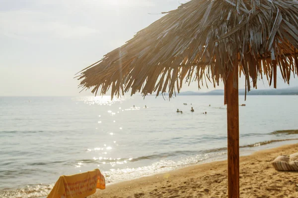 Sombra de palha na praia de areia férias de verão — Fotografia de Stock