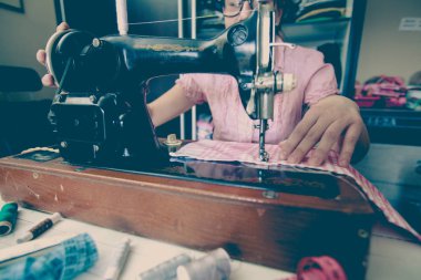 retro dikiş makinesi kullanarak kadın terzi