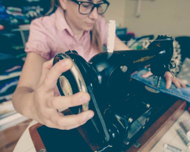 retro dikiş makinesi kullanarak kadın terzi