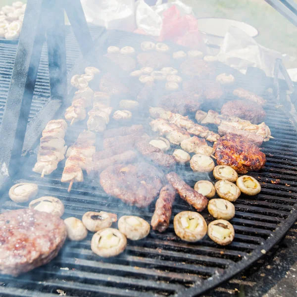 バーベキューバーベキューパーティーで焼き肉と白いシャンピニヨンを満たした品揃え — ストック写真