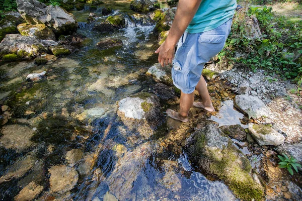 Homem cruzando o riacho descalço — Fotografia de Stock