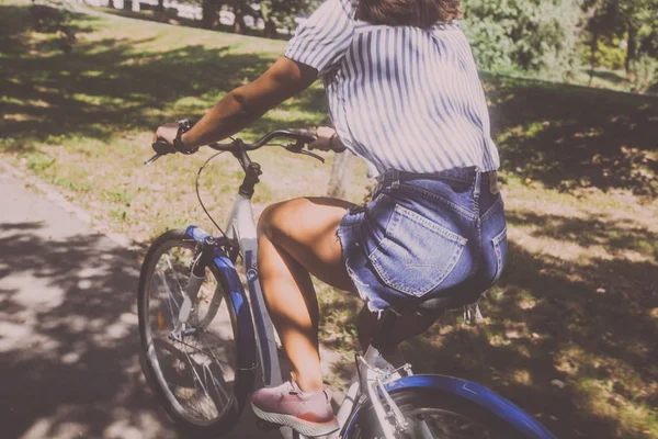 Mooie jonge vrouw paardrijden fiets in het Park achteruitkijk — Stockfoto