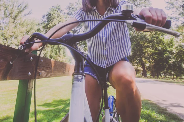 Bonita jovem mulher andar de bicicleta no parque vista traseira — Fotografia de Stock