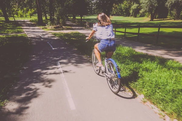 예쁜 젊은 여자 승마 자전거 에 the 공원 후방 보기 — 스톡 사진