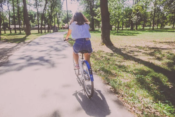 Hübsche junge Frau mit Fahrrad im Park Rückansicht — Stockfoto