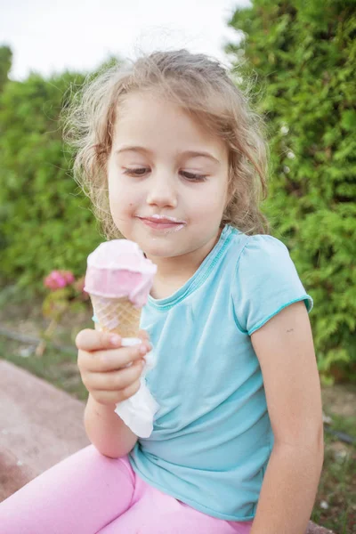 かわいい笑顔の女の子がアイスクリームを食べて — ストック写真