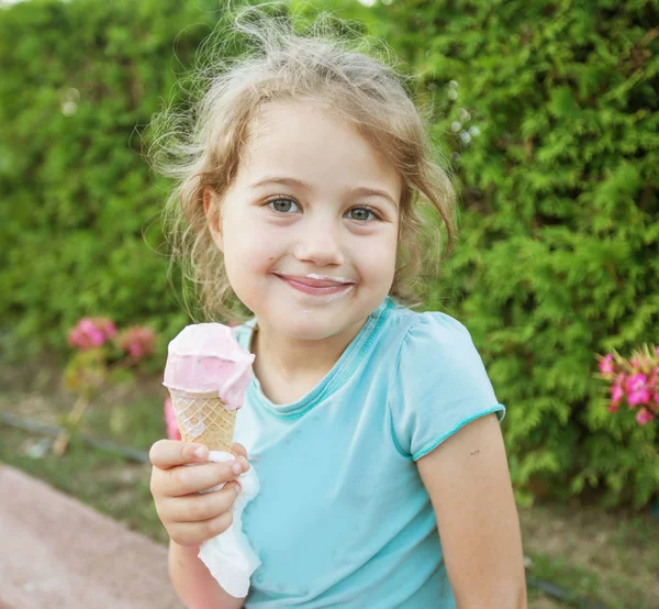 Söt leende liten flicka äter glass — Stockfoto