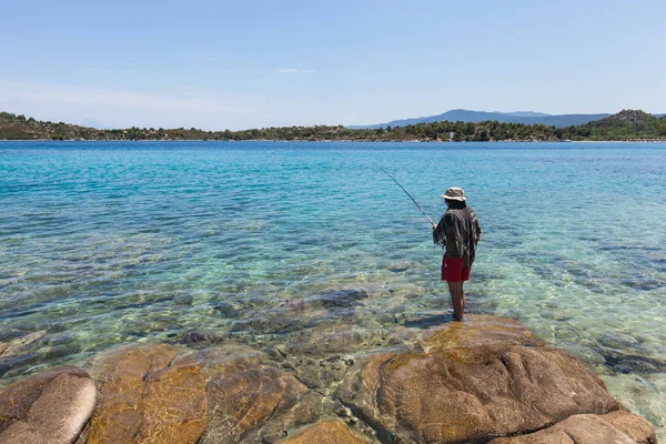 Man vissen in de baai van de zee op de zomerdag — Stockfoto