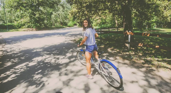 Hübsche junge Frau mit Fahrrad im Park — Stockfoto