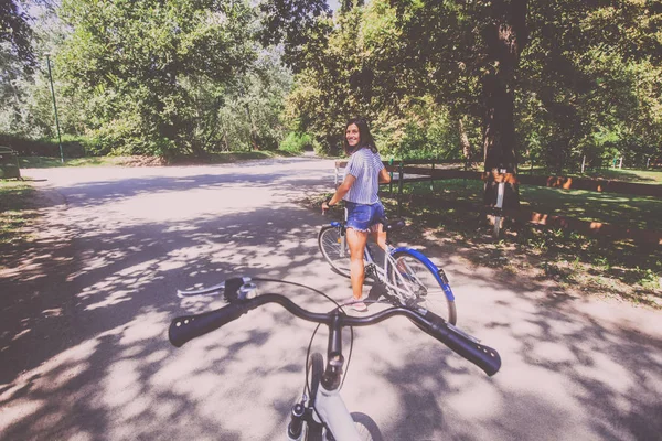 公園で自転車に乗るかわいい若い女性 — ストック写真
