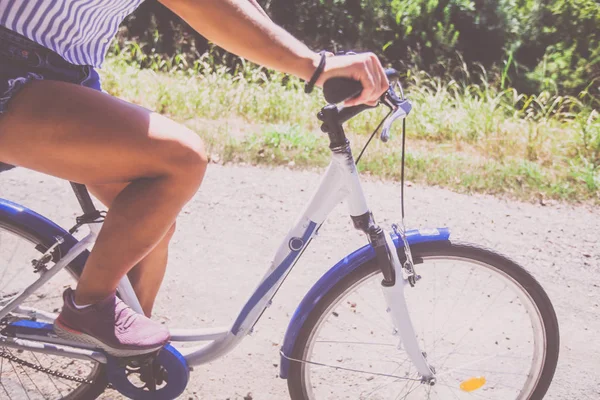 Bonita jovem mulher andar de bicicleta no parque vista traseira — Fotografia de Stock