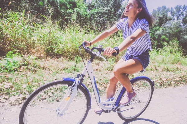 Jolie jeune femme à vélo dans le parc — Photo