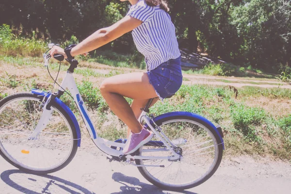 Bonita jovem mulher andar de bicicleta no parque vista traseira — Fotografia de Stock