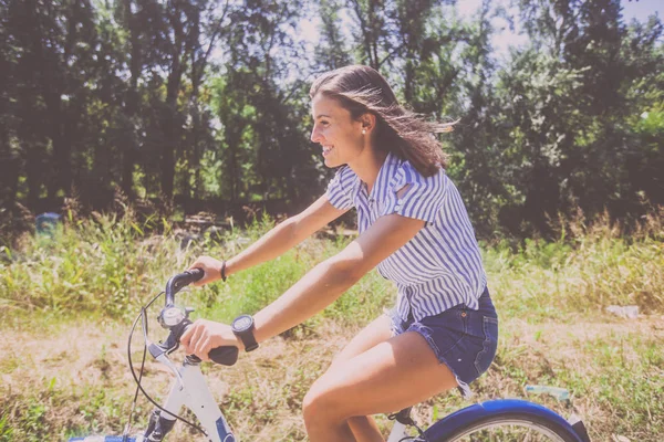 Mulher bonita andando de bicicleta no parque — Fotografia de Stock