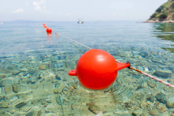 Piros bója úszik a felszínen tiszta türkizkék tenger — Stock Fotó