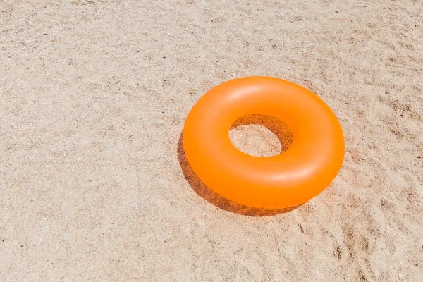 Gul uppblåsbar ring för simning på sandstrand på sommardag — Stockfoto