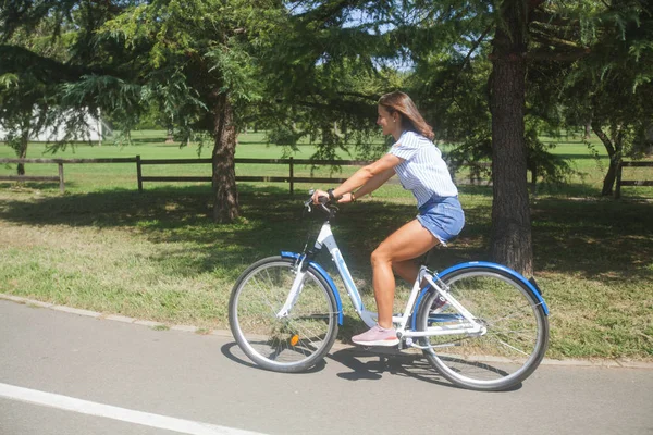 Młoda kobieta jeżdżąca na rowerze w parku — Zdjęcie stockowe