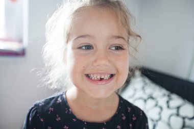 Sevimli gülümseyen küçük kız portresi evde ilk süt dişini düştü gösteren