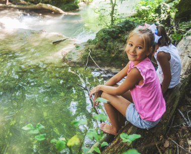 Çocuklar doğada yaz günü Forest Creek 'te eğleniyorlar.