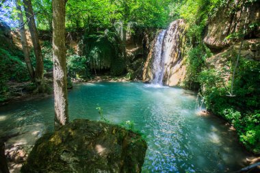 Dinlenmek için gizli bir yer, yaz gününde ormanda şelale , doğal havuz turkuaz renkli su