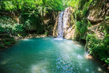 Dinlenmek için gizli bir yer, yaz gününde ormanda şelale , doğal havuz turkuaz renkli su