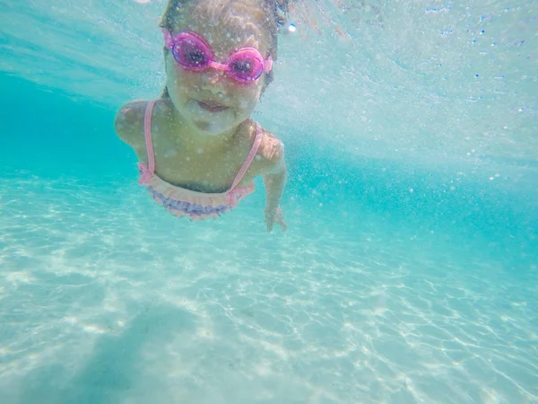 Счастливый ребенок под водой плавает и ныряет в море — стоковое фото