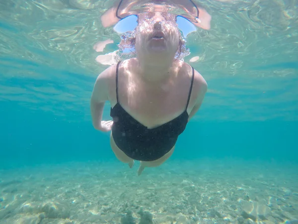 Onderwater foto van vrouw zwemmen in de zee — Stockfoto