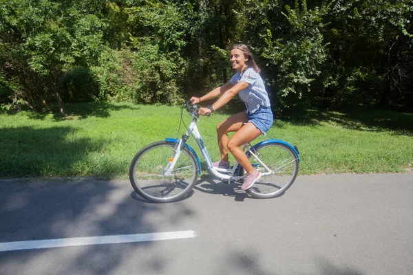 Młoda kobieta jeżdżąca na rowerze w parku — Zdjęcie stockowe