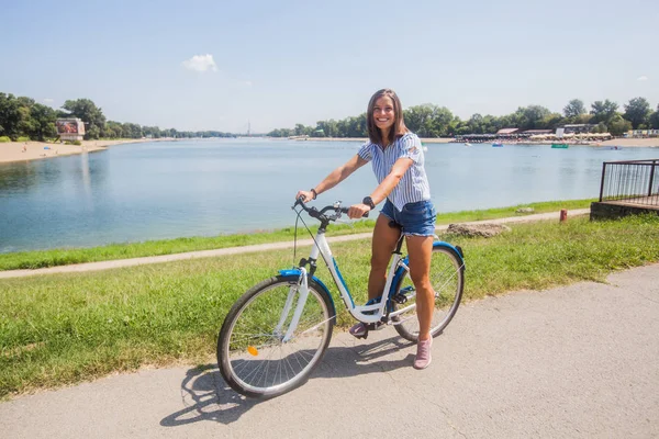 공원에서 자전거를 타고 다니는 젊은 여자 — 스톡 사진