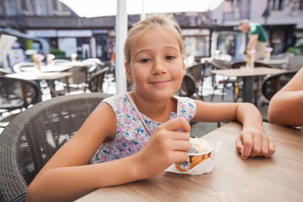 Roztomilá holčička jíst zmrzlinu venkovní kavárna — Stock fotografie