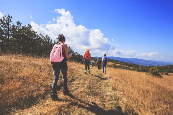 Zadní pohled na nerozpoznatelné lidi s batohem pěší turistiku v přírodě — Stock fotografie