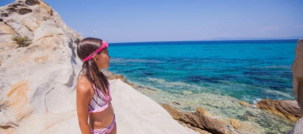 Kind geniet van de zomer zeegezicht op rotsen kust — Stockfoto