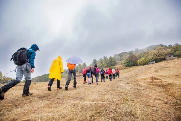 Herziening van onherkenbare mensen wandelen op een regenachtige dag in de natuur — Stockfoto