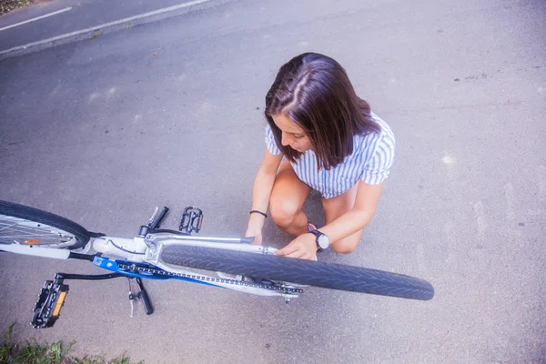 Młoda kobieta sprawdzająca rower — Zdjęcie stockowe