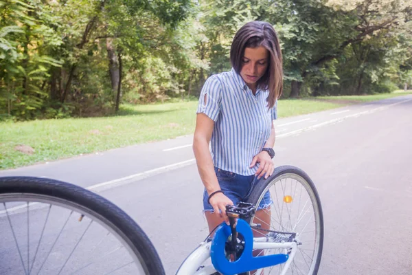 Młoda kobieta sprawdzająca rower — Zdjęcie stockowe
