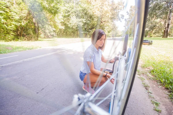 Jonge vrouw controleren haar fiets — Stockfoto