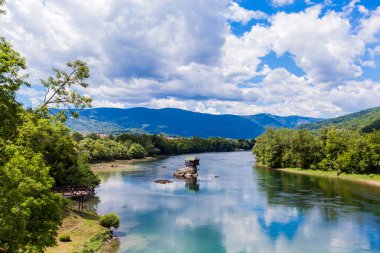 Turistik cazibe, romantik, ahşap kulübe gibi ev, Drina nehrindeki kayalık, bulutlu muhteşem mavi gökyüzü, yaz günü, Sırbistan.