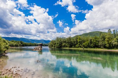 Turistik cazibe, romantik, ahşap kulübe gibi ev, Drina nehrindeki kayalık, bulutlu muhteşem mavi gökyüzü, yaz günü, Sırbistan.