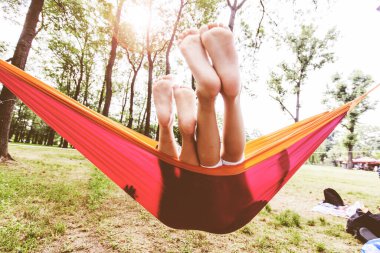 Çocuklar doğanın tadını çıkarıyorlar. Yaz günü hamakta dinleniyorlar..